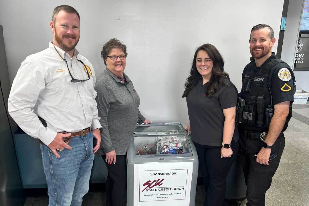 Anderson-County-Sheriff_Ice-Cream SCU employees and Anderson County law enforcement officers standing with donated ice cream freezer.
